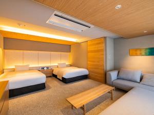 a hotel room with two beds and a couch at AKEKURE Kyoto Shirakawa in Kyoto