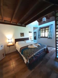 a bedroom with a large bed in a room at Santa Monica Hospedaria in Praia do Rosa