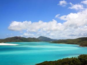 a view of the ocean with mountains in the background at Mango Tides in Airlie Beach