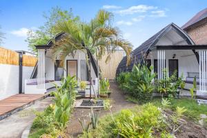 a house with a palm tree in the yard at TottyHouse Gili Trawangan in Gili Trawangan