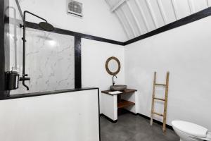 a bathroom with a sink and a toilet and a mirror at TottyHouse Gili Trawangan in Gili Trawangan