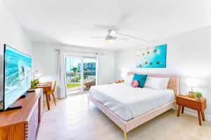 a bedroom with a bed and a flat screen tv at Cocoa Beach Towers - Oceanfront Resort with Heated Pool, Tennis Steps from the Pier in Cocoa Beach