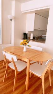 a wooden table with white chairs and a vase with flowers at Ocean view studio with parking in Honolulu