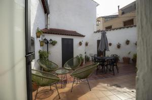 eine Terrasse mit Stühlen, einem Tisch und einem Sonnenschirm in der Unterkunft Casa rural Casa Leles in Lagata