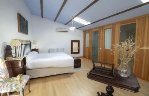 ein Schlafzimmer mit einem Bett und einem Tisch mit einer Blumenvase in der Unterkunft Casa rural Casa Leles in Lagata