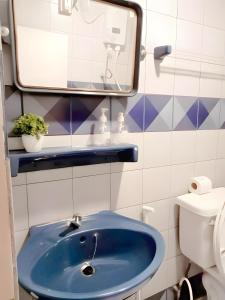 a bathroom with a blue sink and a mirror at oo Mitr Inn Phuket Island - Phuket Old Town yes in Phuket