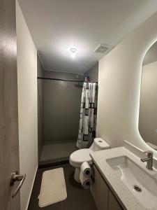 a bathroom with a toilet and a sink and a shower at NU Lomas Garden in Antiguo Cuscatlán +8 photos