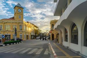 a city street with a clock tower on a building at oo Mitr Inn Phuket Island - Phuket Old Town yes in Phuket +30 photos