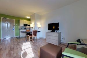 米西索加Studio 6 Toronto - Mississauga with Kitchenettes的客厅设有厨房和带电视的桌子。