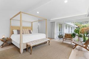 玛莎山Grand Design - Pool, Spa, Playground的白色卧室设有天蓬床和长凳 更多10张照片