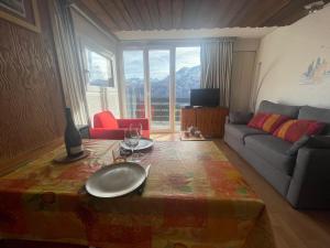 普华露Pra-Loup 1600: Studio cosy 4 pers, vue vallée, centre station - FR-1-165A-207的客厅里有一张桌子和一张沙发