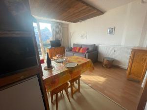 普华露Pra-Loup 1600: Studio cosy 4 pers, vue vallée, centre station - FR-1-165A-207的客厅里有一张桌子和一张沙发