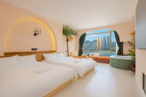 two beds in a room with a large window at Chongqing City Center River View B&B in Chongqing +93 photos