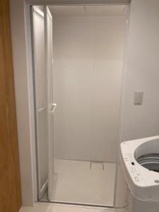 a white shower in a bathroom with a toilet at STAY local 石蔵 in Numazu