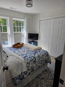 een slaapkamer met een bed met een blauw en wit dekbed bij Perch, for work or wandering the Litchfield Hills in Southbury +35 foto's