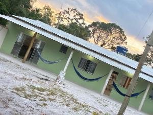 una casa verde con dos mangueras azules en Pousada família, en Prado