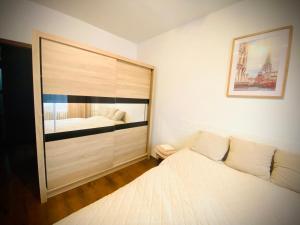 a white bedroom with a bed and a picture on the wall at 3 izbový byt KNM in Kysucké Nové Mesto