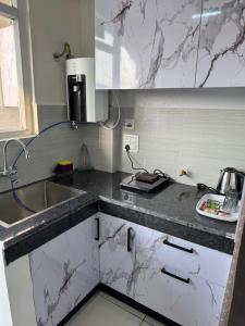 a kitchen with marble counter tops and a sink at Guest Stay Inn 1BHK in Zirakpur