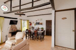 an open living room with a table and chairs at La Rosaleda - Hermosa finca, vista al lago, bosque privado y BBQ in Paipa