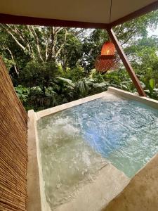 una piscina con ombrellone su un patio di Cabaña El Mamoncillo con Jacuzzi Privado y Malla Catamarán a Sopetrán