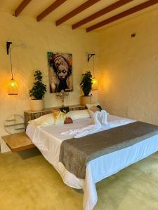 una camera da letto con un grande letto con un gatto steso sopra di Cabaña El Mamoncillo con Jacuzzi Privado y Malla Catamarán a Sopetrán