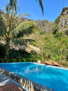 una piscina azul frente a una montaña en Peaceful Garden Tam Cốc, en Văn Lâm