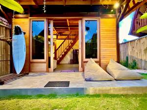 Makaha Bungalow في جيمباران: منزل به لوح تزلج يجلس خارجه