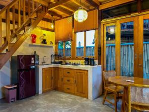 Makaha Bungalow في جيمباران: مطبخ بدولاب خشبي ومغسلة وطاولة +3 صور