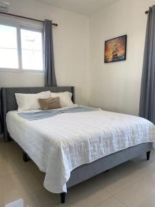 un letto grande in una camera da letto con finestra di Modern 2BR Condo Near the Beach Juan Dolio a Villas del Mar Altre 10 foto