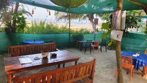 um restaurante com mesa e cadeiras na praia em Oceanview Nohas Guesthouse Arambol em Arambol mais 28 fotografias