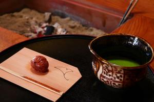 un tavolo con una tazza di liquido verde e un pezzo di cibo di 五作荘 a Mihama