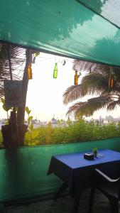 uma mesa azul em uma tenda com uma palmeira em Oceanview Nohas Guesthouse Arambol em Arambol