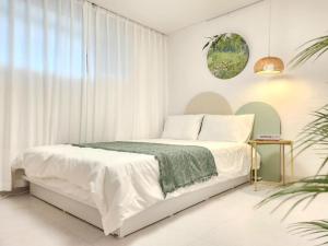 ソウルにあるJamsil Sports Complex Asan Hospital Samsung Hospital KSPO Lotte World Seokchon Lake and near subway Station 3 minutes and near to Gangnam Daechi COEX 10 minutesのベッドと窓のある白い寝室