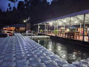a restaurant next to a river at night at Khaosok Foresta Resort in Phanom