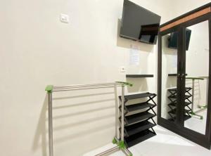 a staircase with a glass railing and a television on the wall at Modern Stay near Roxy Mall Jember RedPartner in Panti