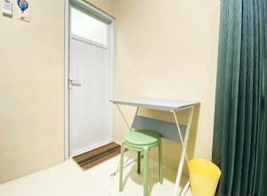 a desk and a stool in a room with a window at Modern Stay near Roxy Mall Jember RedPartner in Panti