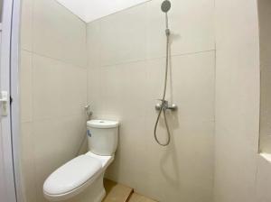 a bathroom with a toilet and a shower at Modern Stay near Roxy Mall Jember RedPartner in Panti +12 photos