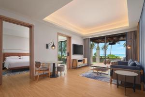 ラゴイにあるFour Points by Sheraton Bintan, Lagoi Bayのベッドとリビングルームがあるホテルの部屋