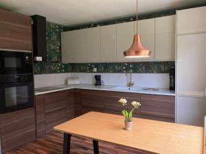 a kitchen with a wooden table with flowers on it at Idyllic vacation home with lakeview in Grönskåra