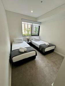 a bedroom with two beds and a window at Manly Moon in Sydney