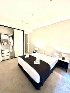 a bedroom with a large bed with two towels on it at Manly Moon in Sydney