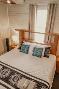 默威伦巴The Little River Cottage - Riverfront Retreat的一间卧室，配有一张床、枕头和一扇窗户