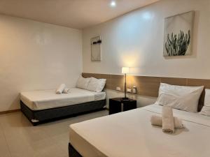 a hotel room with two beds and a lamp at Soi Suites in Talibon +54 photos