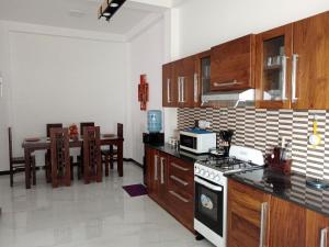 a kitchen with a stove top oven next to a table at Biyagama Highway view Luxury House in Kelaniya