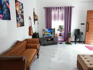 a living room with a couch and a television at Biyagama Highway view Luxury House in Kelaniya