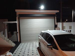 a car parked in front of a garage at night at Biyagama Highway view Luxury House in Kelaniya +2 photos