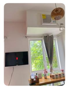Una sala de estar con televisión y una ventana. en La Bella Boutique, en Galicias