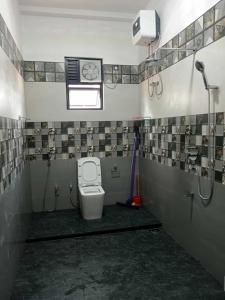 a bathroom with a toilet and a clock on the wall at Biyagama Highway view Luxury House in Kelaniya