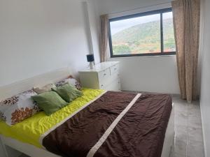 Un dormitorio con una cama con una ventana grande. en Room & Breakfast Praia, en Praia