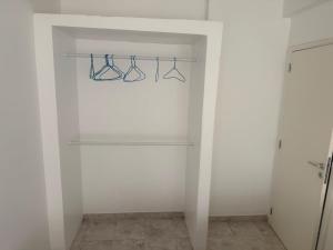 Un armario blanco con tres pares de gafas en un estante. en Room & Breakfast Praia, en Praia